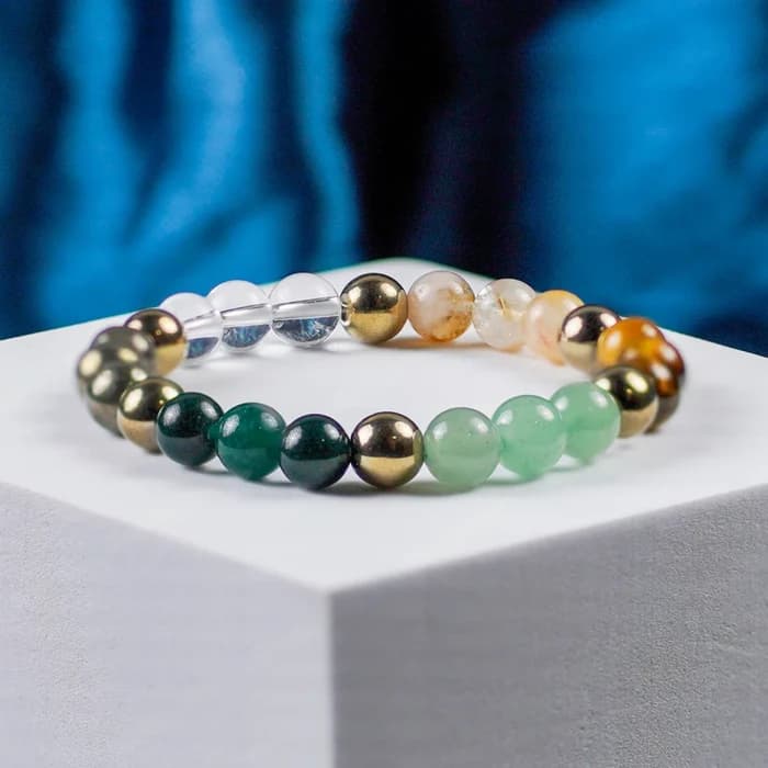 A natural stone bead bracelet displayed on a white plinth