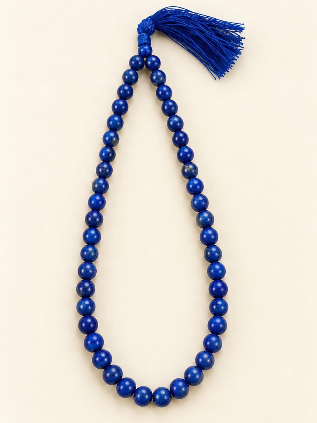 A deep blue gemstone bead mala with a silk tassel