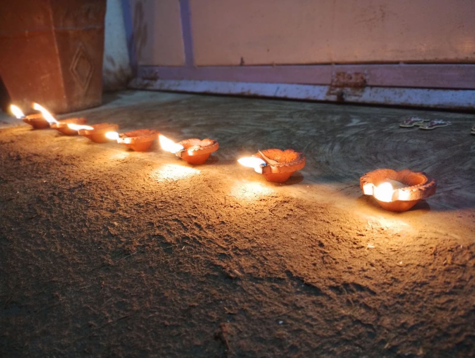 A row of lit clay diyas